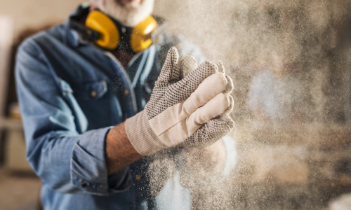 Man clapping dust off of his work gloves